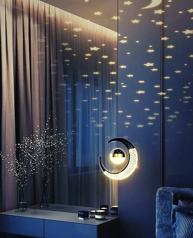half-moon shaped pendant light hanging on the side of the bed emitting lights that have shapes of stars