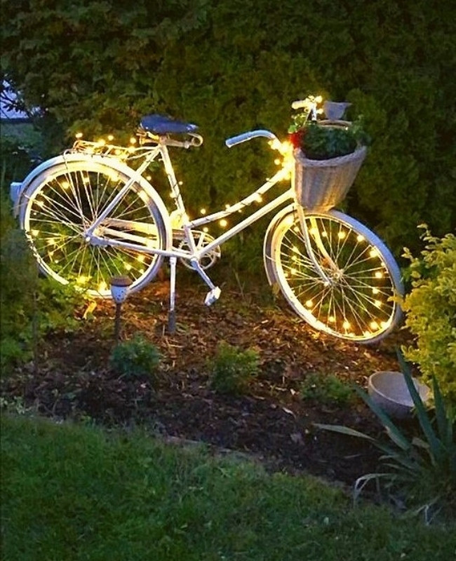 old bike made into a garden decor with fairy lights