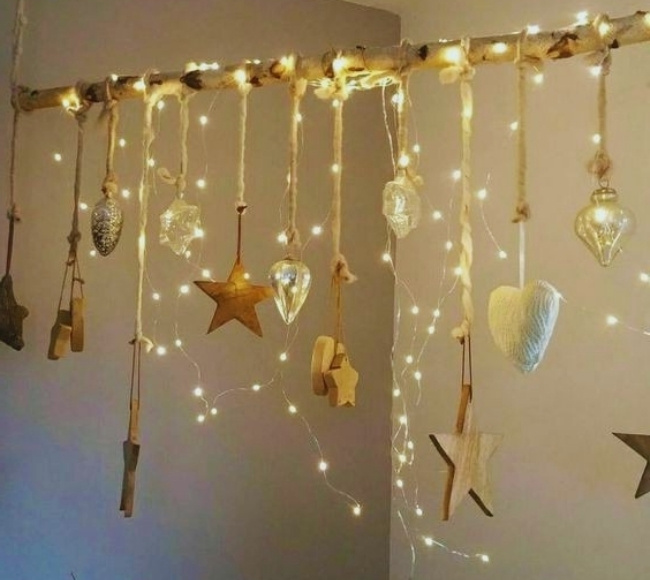 driftwood made into a wall art with stars, shells, and fairy lights