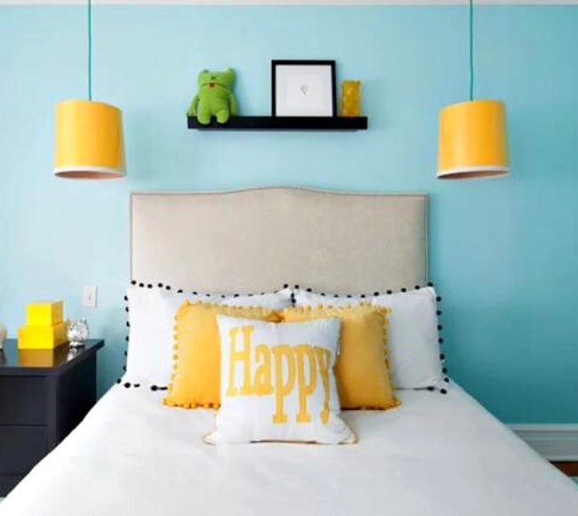 two yellow pendant lights hanging on both sides of the bed