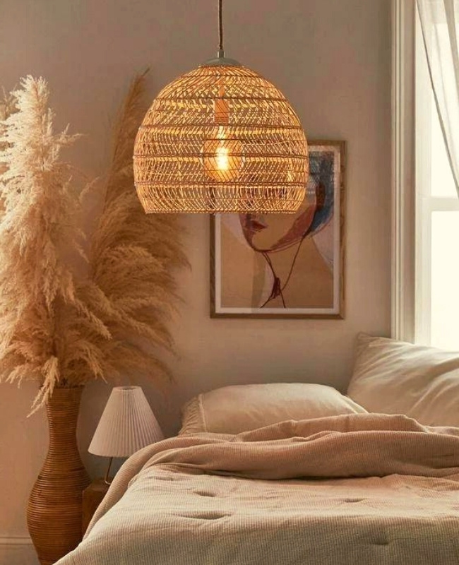 rattan pendant light hanging on top of the bed