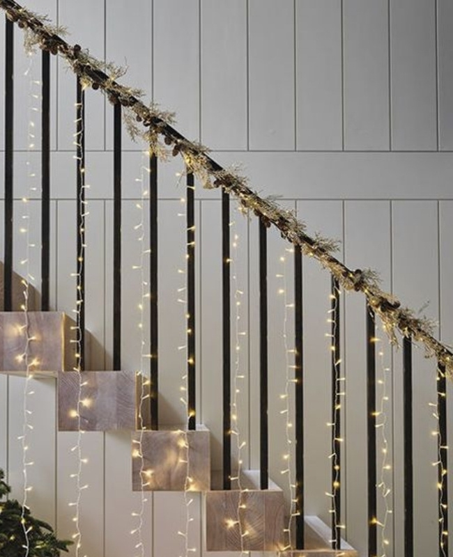staircase decorated with fairy lights and faux vines