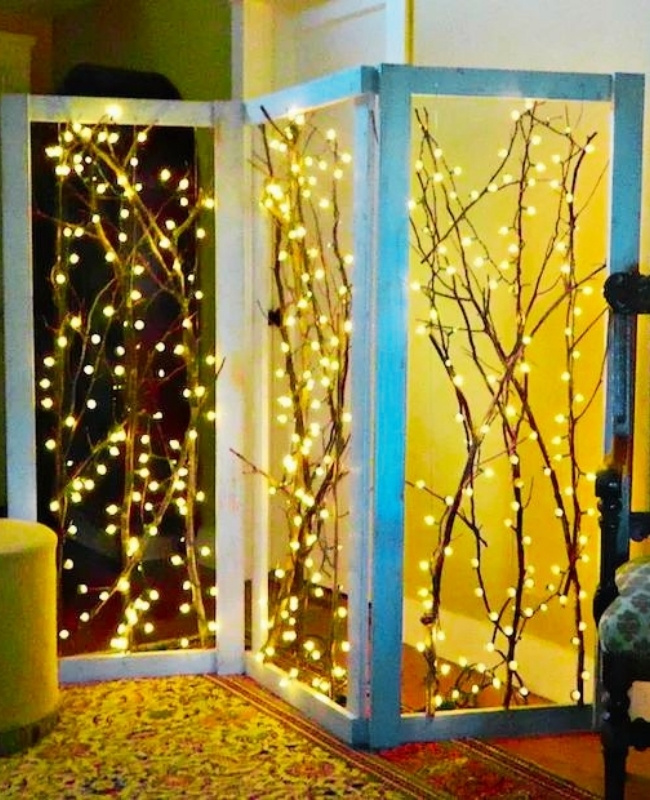 room divider with dried branches and fairy lights