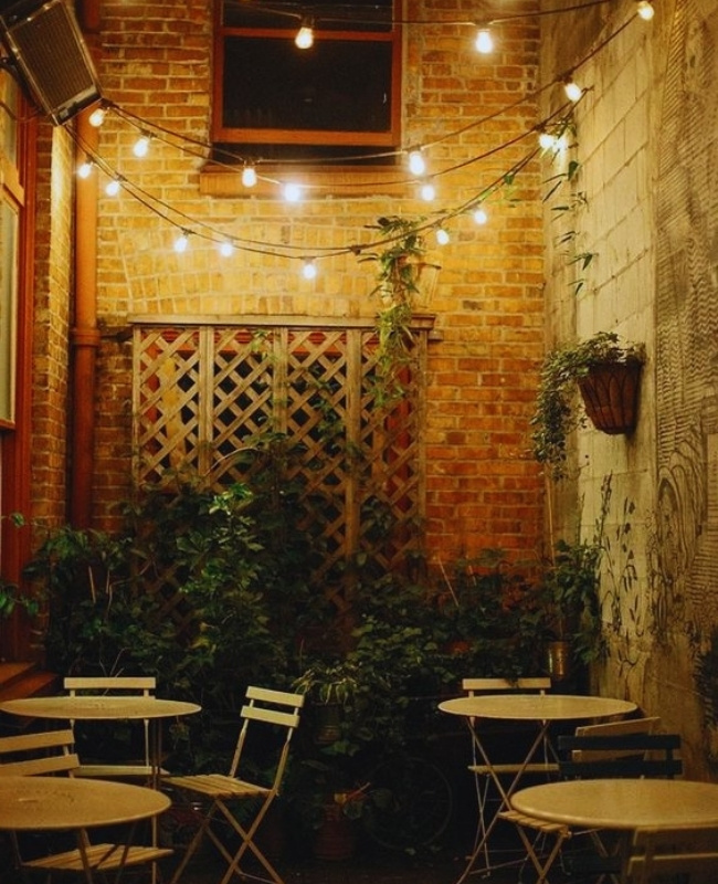 traditional festoon lights hanging outside a garden-inspired cafe